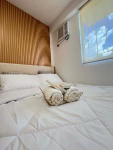 ein Schlafzimmer mit zwei weißen Betten und einem Fenster in der Unterkunft Js Place at Arezzo Place Davao in Davao City