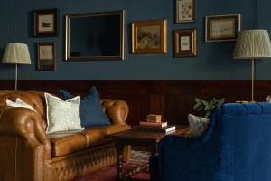 a living room with a leather couch and two chairs at Portrush Atlantic Hotel in Portrush