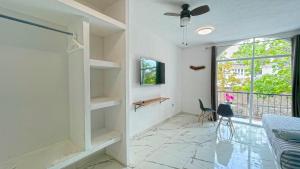 a living room with a ceiling fan and a window at Hotel YA'AX HA' Bacalar in Bacalar