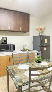 a kitchen with a table with chairs and a refrigerator at Kurt Condo Rental Simple & Cozy in Piapi
