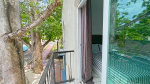 a balcony with a view of a tree at Hotel YA'AX HA' Bacalar in Bacalar