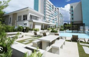 a building with a pool and a patio with a table and chairs at Kurt Condo Rental Simple & Cozy in Piapi