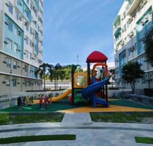 a playground in front of a building with a slide at Kurt Condo Rental Simple & Cozy in Piapi