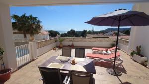 a patio with a table and an umbrella on a balcony at Las estrellas in Peniscola