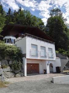 a white building with a balcony on top of it at Landhaus Schmittenblick in Zell am See