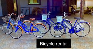 three blue bikes are parked in front of a building at La Plume in Ban Phe