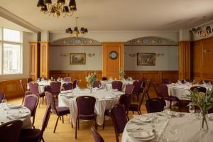 a room with tables and chairs and a chandelier at Portrush Atlantic Hotel in Portrush
