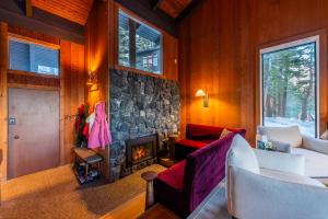 a living room with a fireplace and a stone wall at The Icelander at Mammoth Point in Mammoth Lakes
