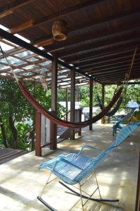 a hammock on a patio with two blue chairs at Dive and Green Capurgana in Capurganá