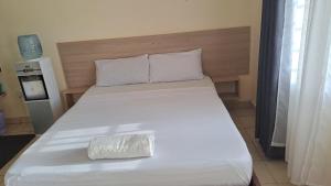 a large white bed with a pillow on it at Diani Haven Swahili modern studio in Kwale