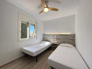 two beds in a room with a ceiling fan at Agi Rescator Apartments in Roses +67 photos