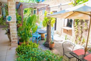 a patio with a table and an umbrella and plants at Virgínia Palace in Corumbá