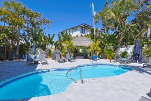 a swimming pool with palm trees and a house at The Inn on Siesta Key in Siesta Key