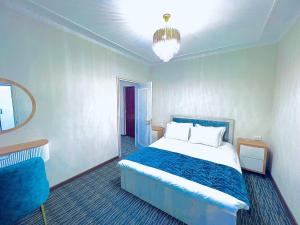a bedroom with a bed and a chair in it at Volidam Hotel in Qarshi