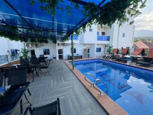 a swimming pool with tables and chairs next to a building at Amelia Aparthotel in Buea
