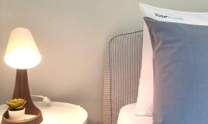 a lamp sitting on a table next to a pillow at 1000Jo Apartment T3 in Gulpilhares +25 photos