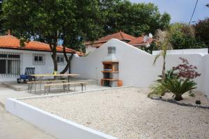 a backyard with a table and a bench and a fence at 1000Jo Apartment T3 in Gulpilhares