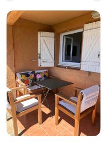 a patio with a table and two chairs and a window at Côte d azur Magnifique studio in Les Issambres +5 photos