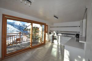 a kitchen with a large sliding glass door with a balcony at Chalet D' Edmond in Bourg-Saint-Maurice