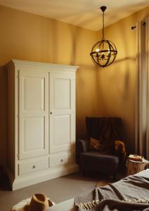 a bedroom with a cabinet and a chair and a chandelier at Amatacasa Villa Rosa in Melfi +28 photos