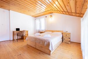 a bedroom with a bed and a wooden ceiling at Кума Лиса in Devin