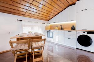 a kitchen with white cabinets and a wooden ceiling at Кума Лиса in Devin
