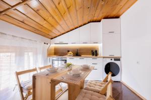 a kitchen with a wooden table and white cabinets at Кума Лиса in Devin +16 photos