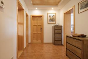 a hallway with a wooden door and a dresser at Tatry TOP Dom in Vavrišovo