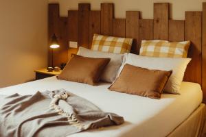 a bedroom with a large bed with brown and white pillows at Amatacasa Villa Rosa in Melfi