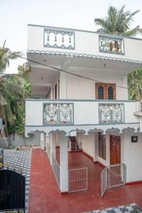 a white house with a red floor at lagoon holiday villa Jaffna in Tavadi