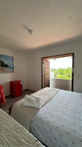 two beds in a room with a window at villa coqueiro praia do prea in Cruz