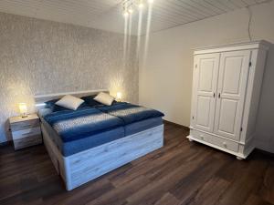 a bedroom with a bed and a white cabinet at Gemütlich in Minden in Minden