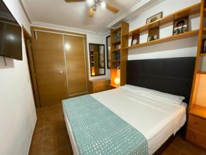 a bedroom with a large bed with wooden shelves at Apto 1 Hab, Terraza & Piscina, 5 min Playa in Playa de Gandia +47 photos
