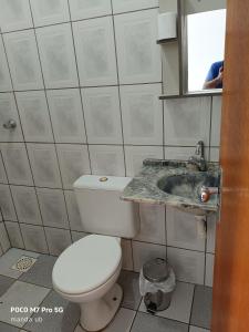 a bathroom with a toilet and a sink at FARO FINO 203 x in Goiânia