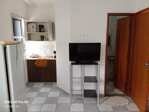a television sitting on a stand in a kitchen at FARO FINO 203 x in Goiânia