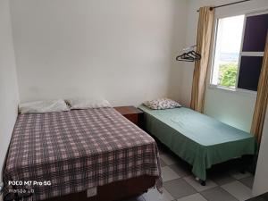 a bedroom with two beds and a window at FARO FINO 203 x in Goiânia