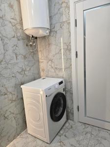 a washer and dryer in a bathroom next to a door at Svobody 5 in Uzhhorod +2 photos