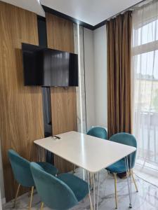 a meeting room with a white table and blue chairs at Svobody 5 in Uzhhorod