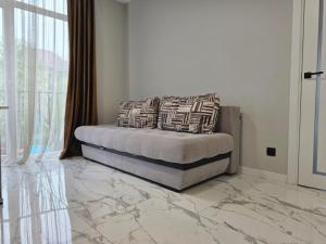 a bedroom with a bed with marble floors and a window at Svobody 5 in Uzhhorod