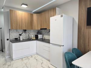 a kitchen with white cabinets and a refrigerator at Svobody 5 in Uzhhorod