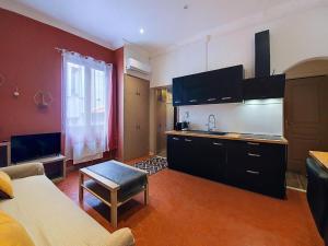 a kitchen with a couch and a table in a room at Brise Douce in Perpignan