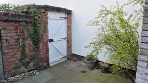 a white garage door in a brick wall at Double rooms in Crosby