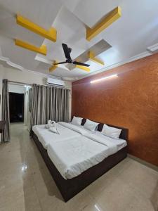 a bedroom with a large bed with a ceiling fan at Hotel Maharaja Path in Ujjain