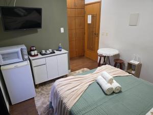 a bedroom with a bed with towels on it at Flat 108B com lazer próx ao centro in Serra Negra