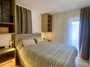 a bedroom with a bed and a window at Apartmani Perić in Stari Grad