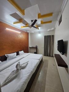 a bedroom with a large bed with two birds on it at Hotel Maharaja Path in Ujjain