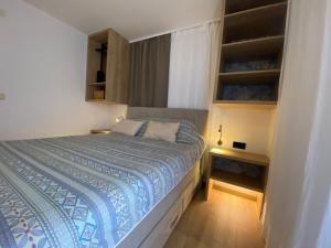 a small bedroom with a bed and a night stand at Apartmani Perić in Stari Grad
