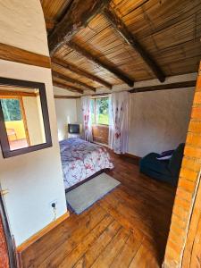 a bedroom with a bed in a room with wooden floors at Cabaña Bachué in Sutatausa +18 photos