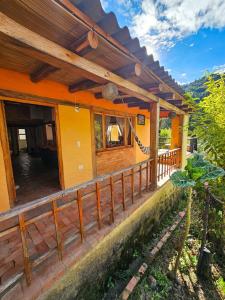 a house with a porch and a fence at Cabaña Bachué in Sutatausa