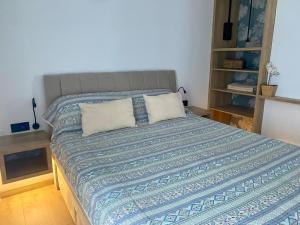 a bed with two pillows on it in a room at Apartmani Perić in Stari Grad